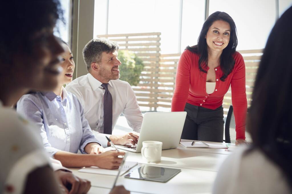 Hispanic businesswoman listening to colleagues at a meeting