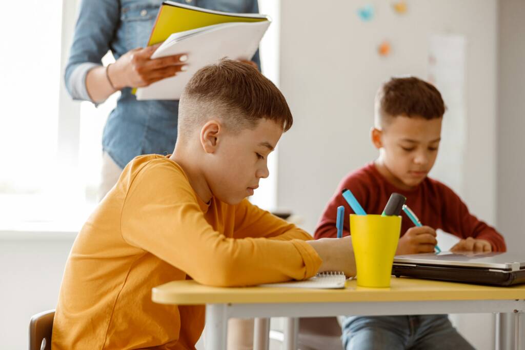 Two schoolchildren during a lesson and a test at school